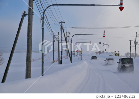 雪に覆われた道路を走る自動車の列 122486212