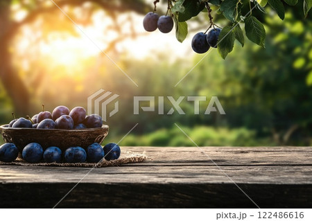 A bowl of blue plums sits on a wooden table 122486616