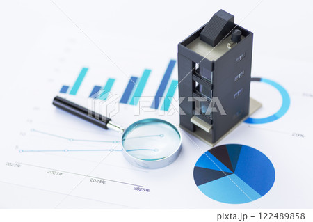 青いグラフと会社のビルとルーペ 122489858