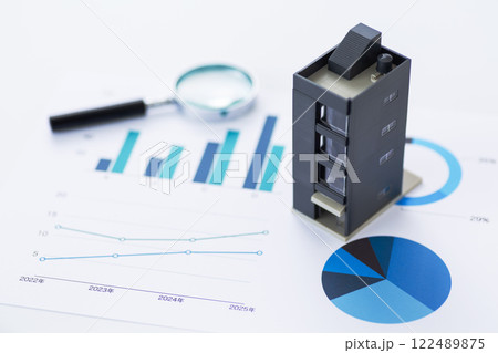 青いグラフと会社のビルとルーペ 122489875