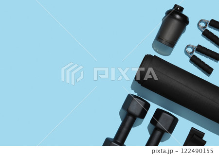 Black workout equipment for training at home on blue background. Fitness, sport items, healthy lifestyle concept. Copyspace Black workout equipment for training at home on blue background. Fitness, sport items, healthy lifestyle concept. Copyspace 122490155