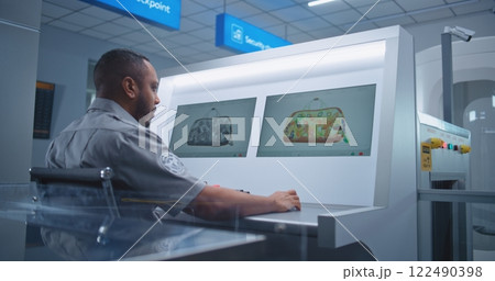 Security Officer Controls Luggage Screening on Computer Monitors Using Modern Software 122490398