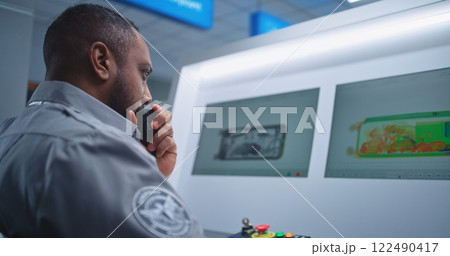 Security Officer Monitors Baggage Screening on Computer, Finds Suspicious Object, Talks by Walkie-Talkie Security Officer Monitors Baggage Screening on Computer, Finds Suspicious Object, Talks by Walkie-Talkie 122490417
