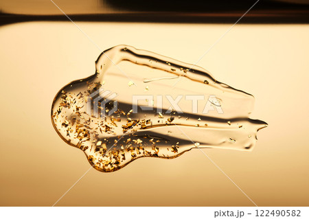 A delicious drop of 24k gold serum on a gold background. 122490582