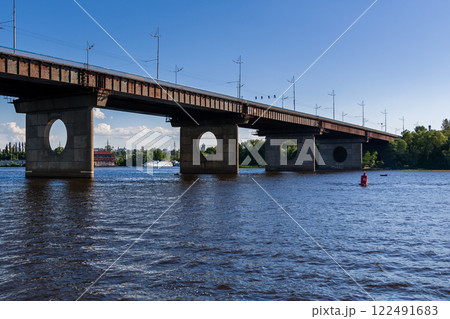 Bridge on a river against a blue sky and clouds 122491683