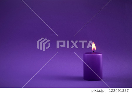 Purple Candle. A single purple candle burning with a soft flame Purple Candle. A single purple candle burning with a soft flame 122491887