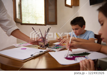 Children Enjoy Art Activities at Home Using Colorful Paint and Brushes 122491926