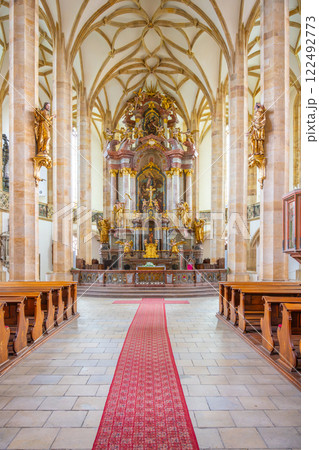 The interior of the Church of the Assumption of the Virgin Mary showcases stunning late Gothic architecture, featuring intricate columns, a vibrant altar, and a richly detailed design. 122492773