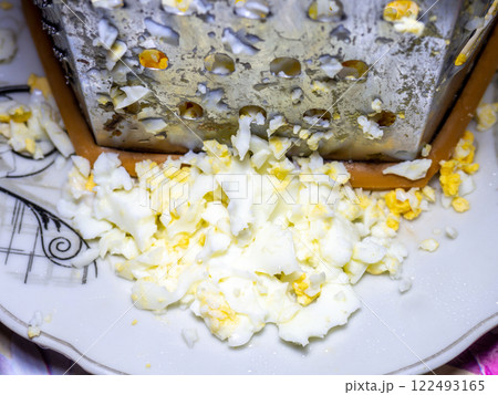 Grated egg. Protein. protein product. Grated boiled egg on a kitchen board. Grated egg. Protein. protein product. Grated boiled egg on a kitchen board. 122493165