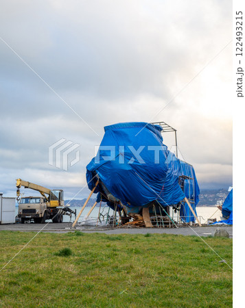 large yacht is covered with a tarpaulin. The ship is under repair. large yacht is covered with a tarpaulin. The ship is under repair. 122493215