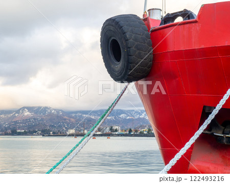 nose of the ship is red. Tire on the bow of the ship. Safety . Moored ship. 122493216