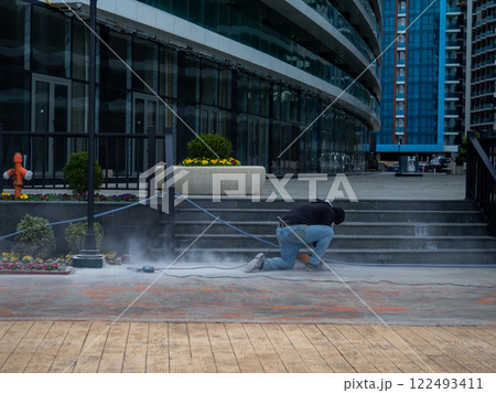 workers are working. Hard work. A man polishes steps with a grinder. 122493411