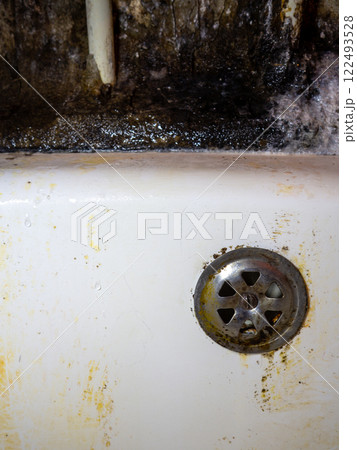 Bathroom drain dirty. Siphon element. Plumbing. Mold on bathroom enamel. Black dots of mold and yellow plaque. Requires cleaning. Before using cleaning products. 122493528