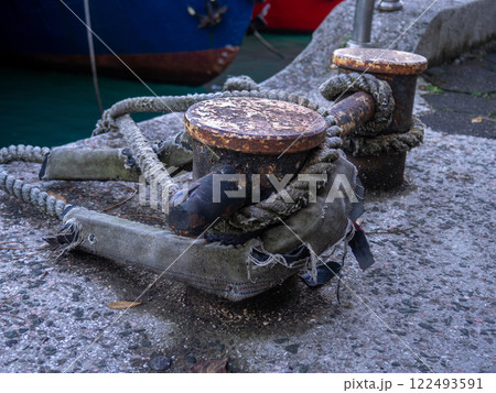 rope goes into the water from the bollard. Attaching boats to the pier. Port area. Sea port. rope goes into the water from the bollard. Attaching boats to the pier. Port area. Sea port. 122493591