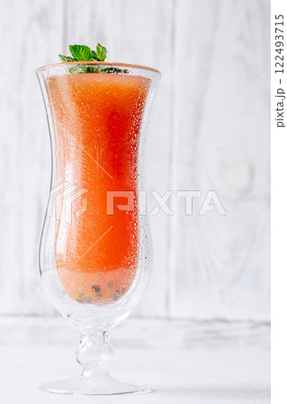 Jamaican Me Crazy cocktail in hurricane glass with mint garnish on white wooden Jamaican Me Crazy cocktail in hurricane glass with mint garnish on white wooden 122493715