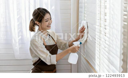 壁掃除をする若いハウスクリーニングの女性 122493913