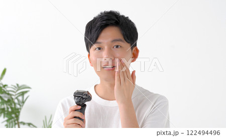 電気シェーバーで髭を剃る男性 122494496
