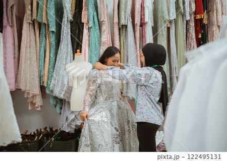 Girls Shopping for Elegant Dresses in a Boutique with Colorful Fabrics Girls Shopping for Elegant Dresses in a Boutique with Colorful Fabrics 122495131