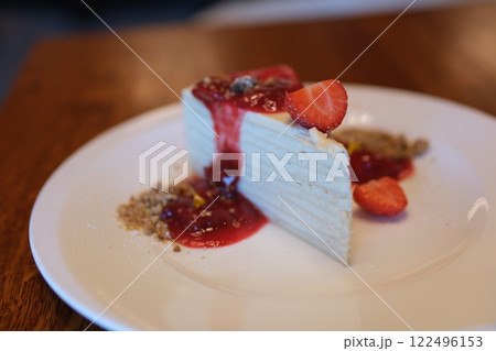 thin cakes with cream white cake thin cakes many layers with strawberry jam eat with a spoon from a white plate thin pancakes smeared with cream for breakfast 122496153
