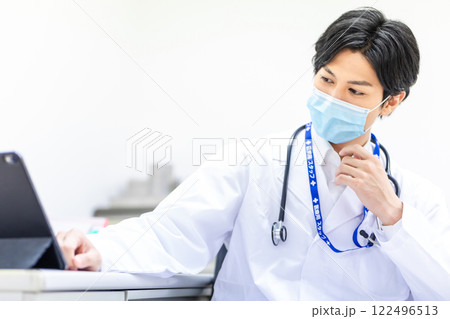 診察を行う若い医師 診察を行う若い医師 122496513