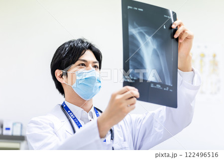 レントゲン写真を見て診断をする若い医師 122496516