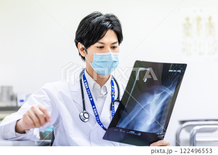 レントゲン写真を見て診断をする若い医師 122496553