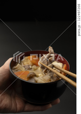 豚汁のお椀を手に持って箸で豚肉を持ち上げる 豚汁のお椀を手に持って箸で豚肉を持ち上げる 122497208