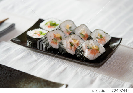 Homemade salmon salad sushi on black plate with white placemat on table. Japanese healthy food. Selective focus. 122497449