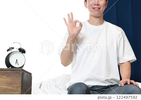 ベッドの上でOKをする若いアジア人男性 ベッドの上でOKをする若いアジア人男性 122497592