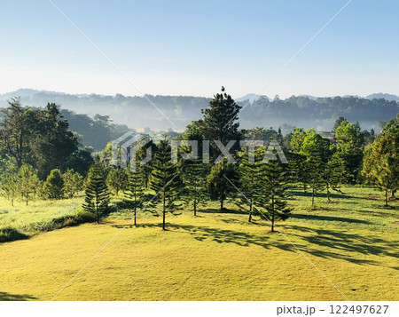Scene of sunrise with fog in the valley, green field and green trees in the Northern of Thailand Scene of sunrise with fog in the valley, green field and green trees in the Northern of Thailand 122497627