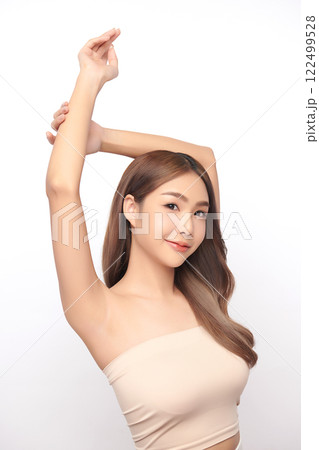 Beautiful Young Asian woman lifting hands up to show off clean and hygienic armpits or underarms on white background, Smooth armpit cleanliness and protection concept 122499528