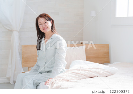 朝ベッドから起床するシニア女性 朝ベッドから起床するシニア女性 122500372