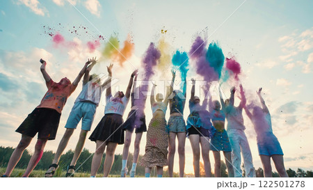 School friends celebrate the end of the year by joyfully throwing colorful powder in the air while jumping 122501278