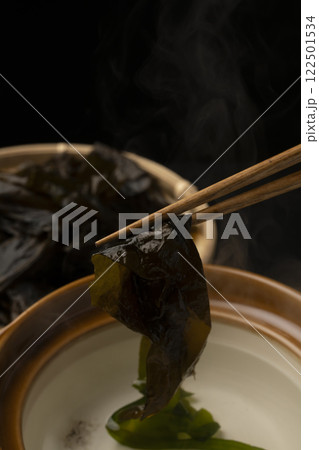 生わかめをしゃぶしゃぶで食べる 箸で生わかめを持ち上げる 生わかめをしゃぶしゃぶで食べる 箸で生わかめを持ち上げる 122501534