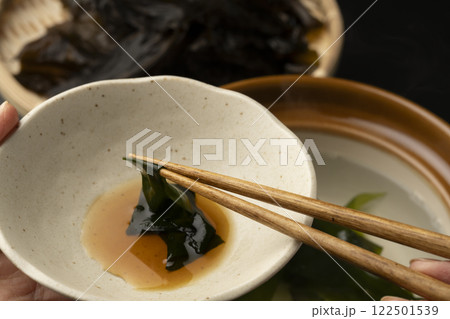 生わかめをしゃぶしゃぶで食べる 箸で生わかめを持ち上げる 生わかめをしゃぶしゃぶで食べる 箸で生わかめを持ち上げる 122501539