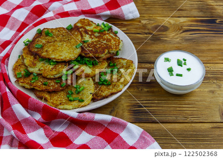 Potato pancakes with sour cream on a wooden table 122502368