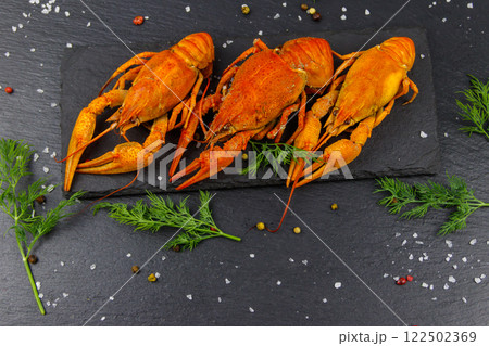 Red boiled crayfish with dill and spices on black slate background. Top view 122502369