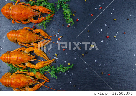 Red boiled crayfish with dill and spices on black slate background. Top view 122502370