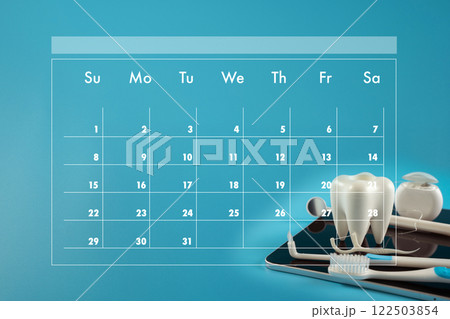 dental plan calendar with numbers 1-31. A toothbrush and a pair of dental tools are placed on the calendar dental plan calendar with numbers 1-31. A toothbrush and a pair of dental tools are placed on the calendar 122503854