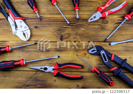 Set of different pliers and screwdrivers on wooden background. Top view, copy space 122506317