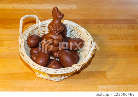 Basket with Easter eggs and Easter bunny on wooden table Basket with Easter eggs and Easter bunny on wooden table 122506465