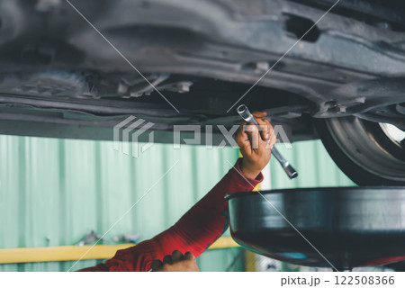 Car mechanic drain the old lubricant engine oil 122508366