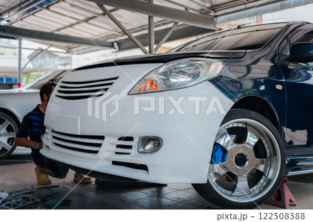 Checking car body work fiber bumper at car garage 122508388