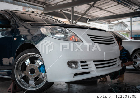 Checking car body work fiber bumper at car garage 122508389