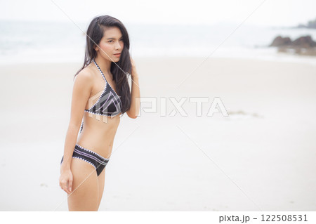 Beautiful young asian woman standing with happiness for relax on beach in tropical. 122508531