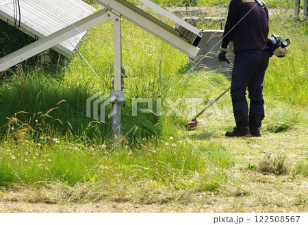 雑草が伸びたソーラー発電所の草刈り作業の様子 122508567