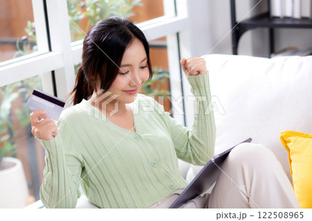 Young asian woman sitting on sofa using tablet computer shopping online with credit card. Young asian woman sitting on sofa using tablet computer shopping online with credit card. 122508965