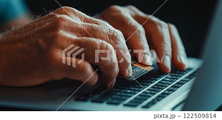 Senior man using credit card while shopping online on laptop 122509814