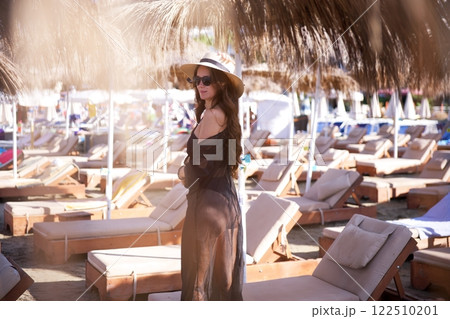 Stylish woman in black beach outfit at resort Stylish woman in black beach outfit at resort 122510201
