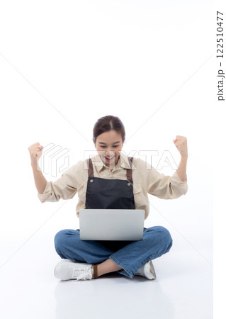 Portrait young asian business woman wearing apron holding laptop computer isolated. 122510477